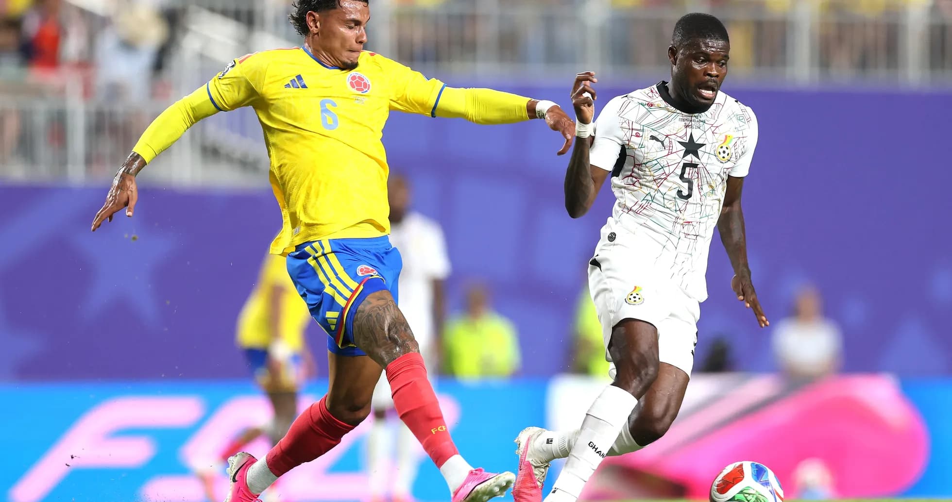 Colombian player challenging Ghanaian opponent during match Colombian player challenging Ghanaian opponent during match