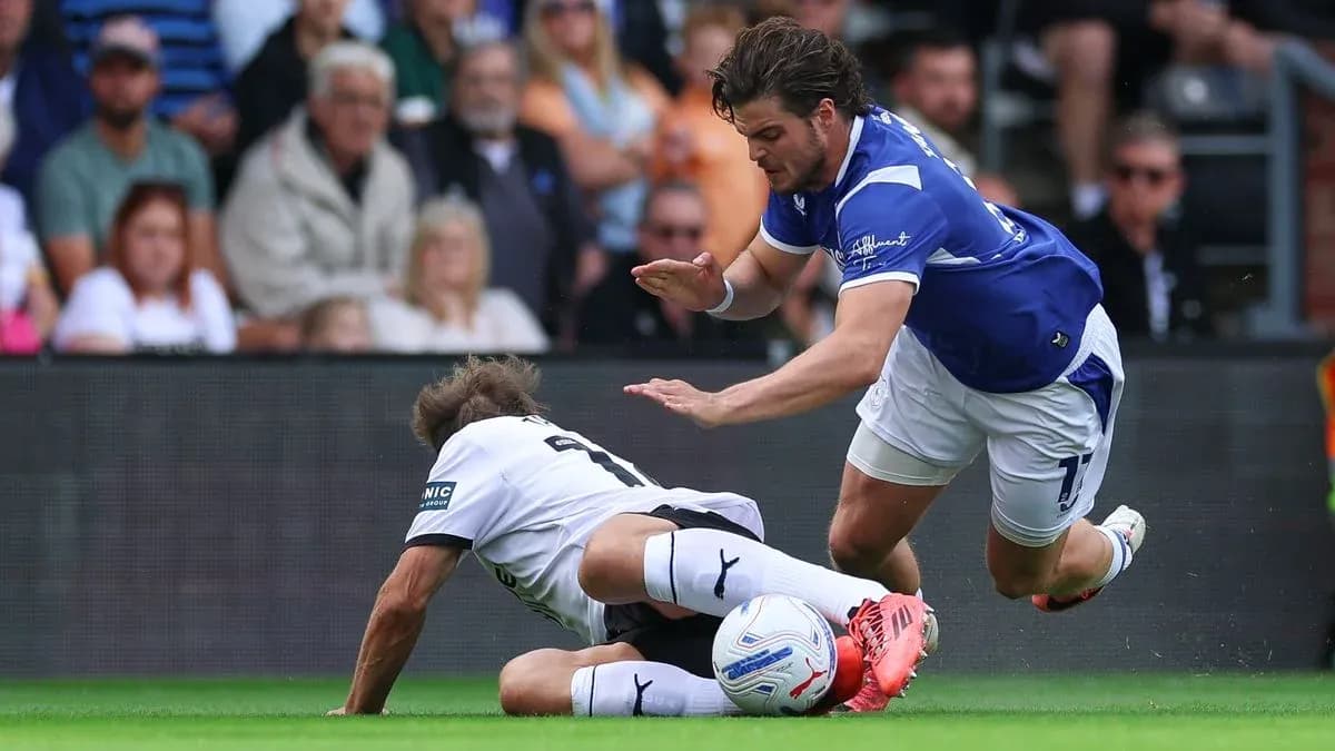 Player tackling opponent during a football match Player tackling opponent during a football match
