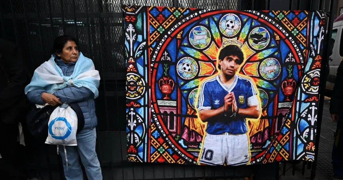 Woman in Argentina jersey beside mural of Maradona Woman in Argentina jersey beside mural of Maradona