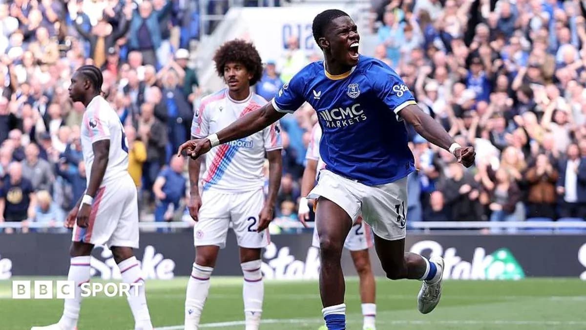 Everton player celebrating goal with teammates in match Everton player celebrating goal with teammates in match