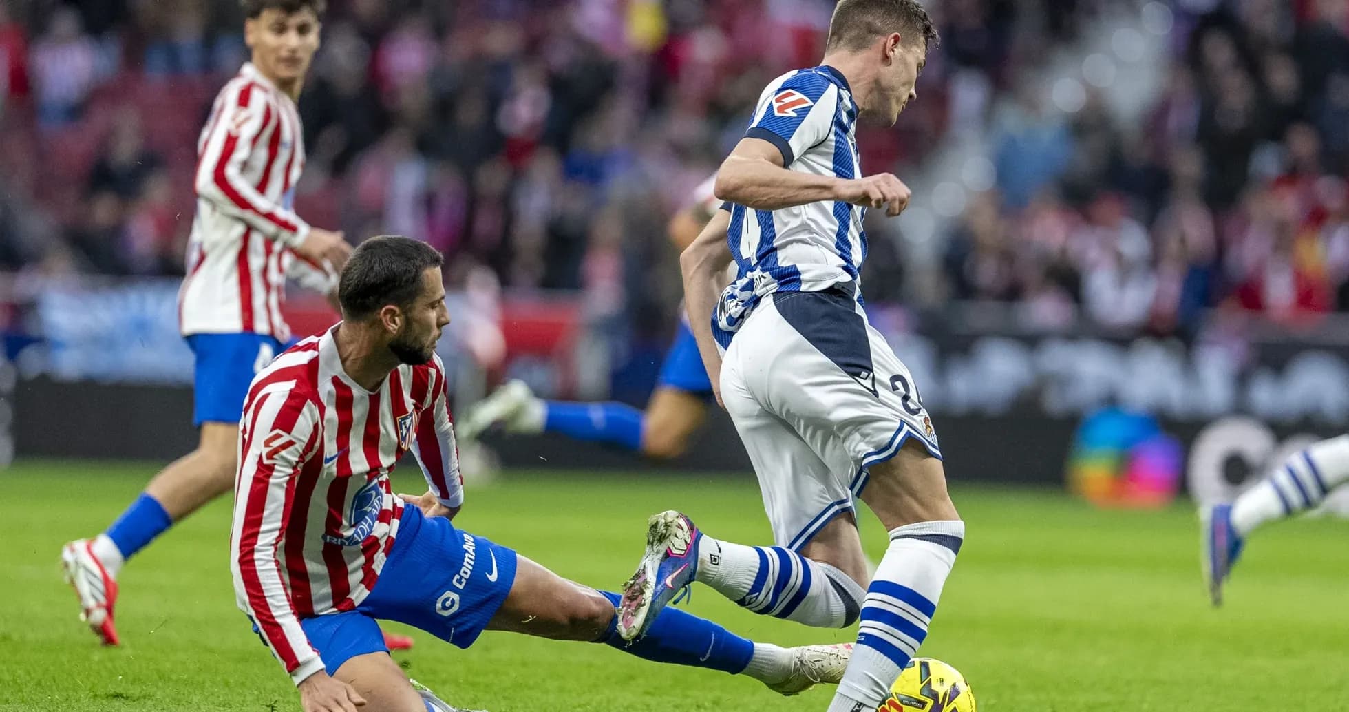 Real Sociedad player tackling Atletico Madrid opponent Real Sociedad player tackling Atletico Madrid opponent