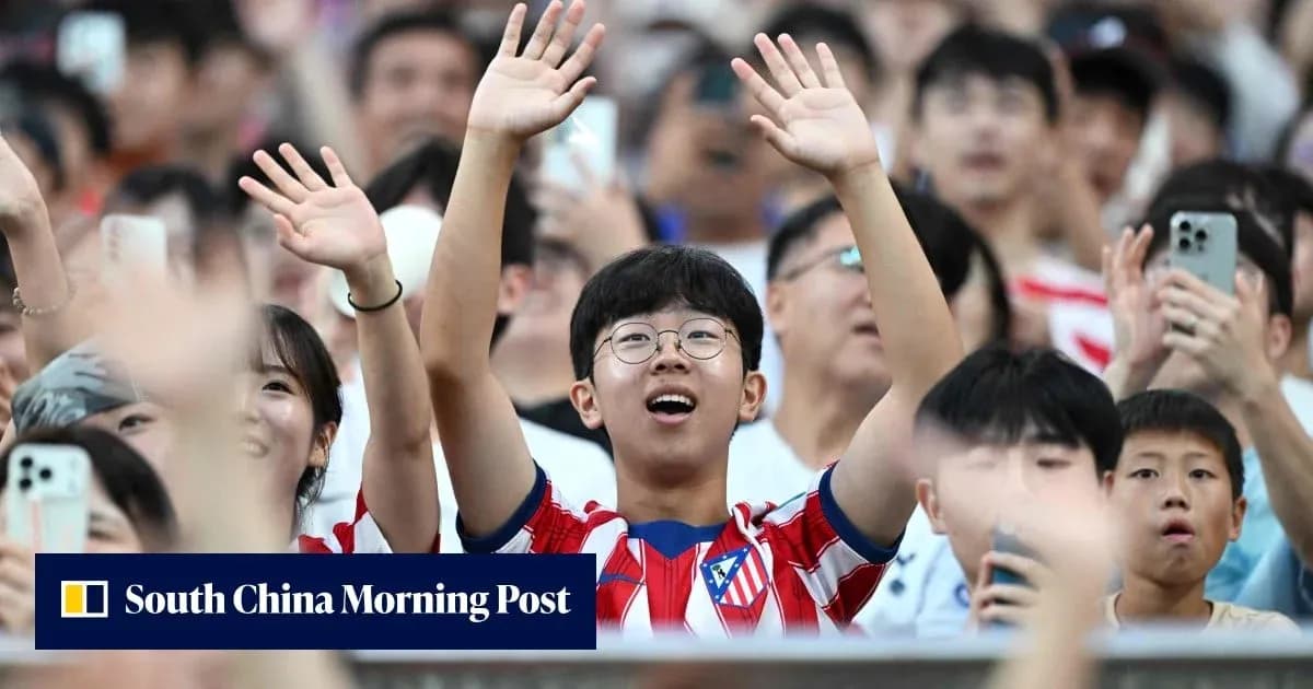 Fan wearing Atletico Madrid jersey cheering in crowd Fan wearing Atletico Madrid jersey cheering in crowd