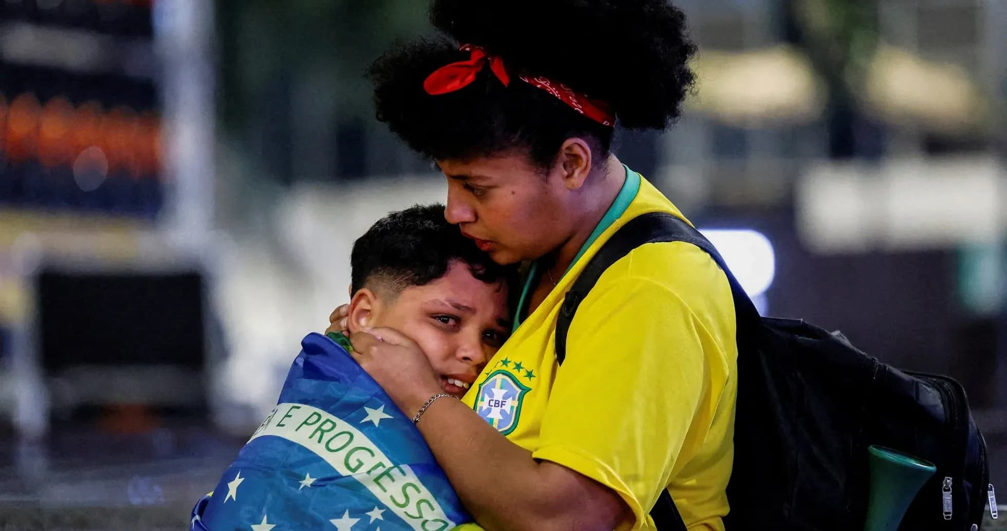 Woman holding child wrapped in Brazilian flag Woman holding child wrapped in Brazilian flag