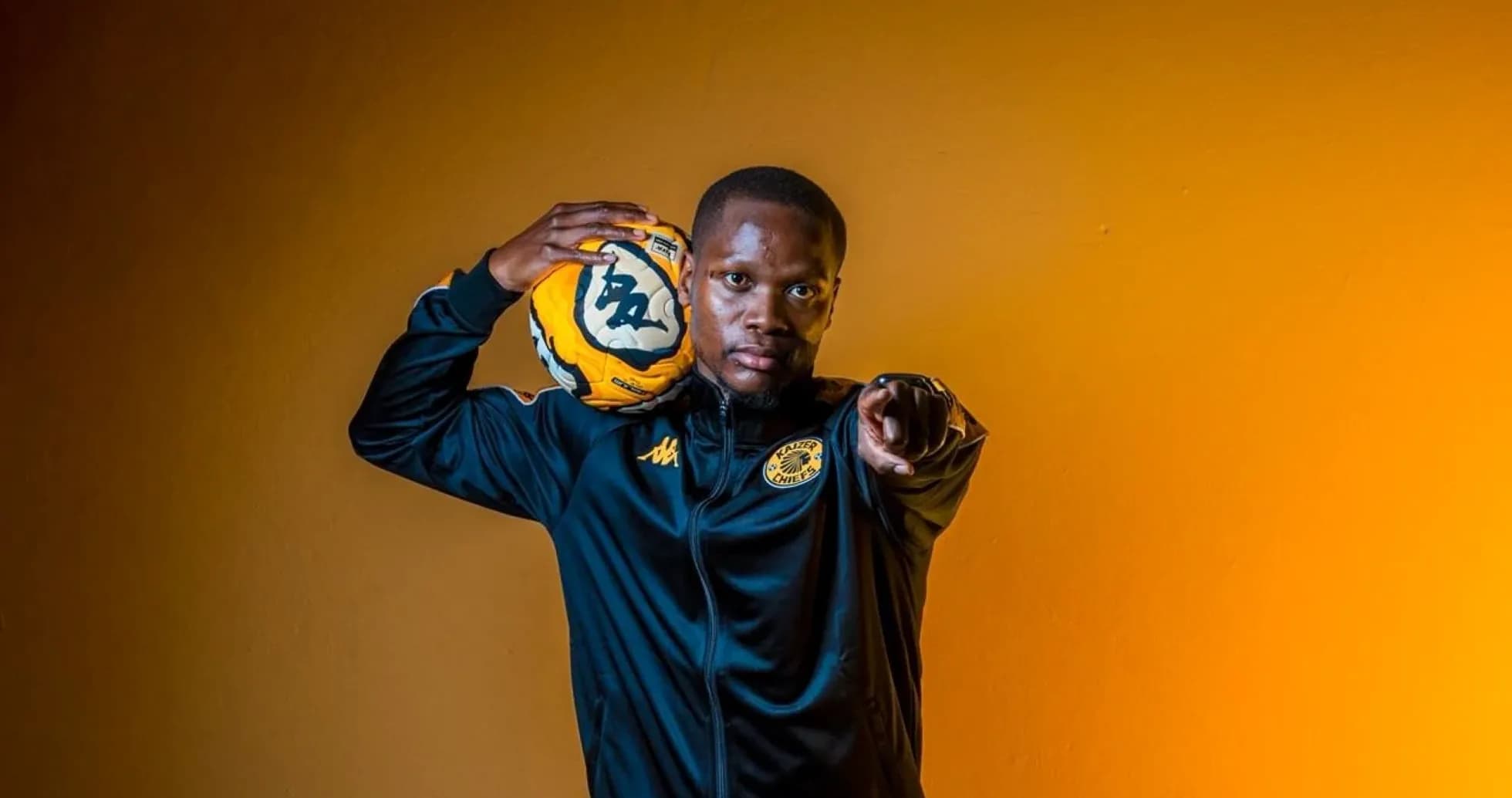 Player pointing while holding a soccer ball Player pointing while holding a soccer ball