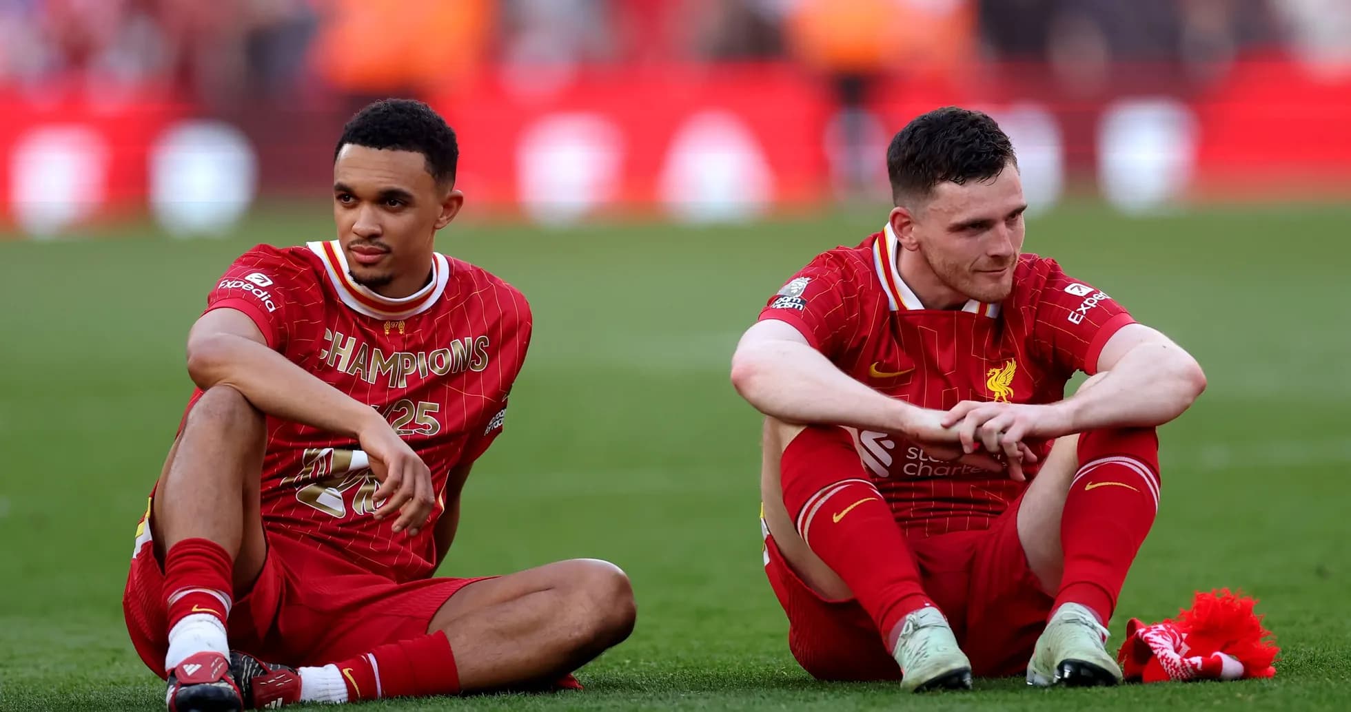 Two Liverpool players sitting on pitch after match Two Liverpool players sitting on pitch after match