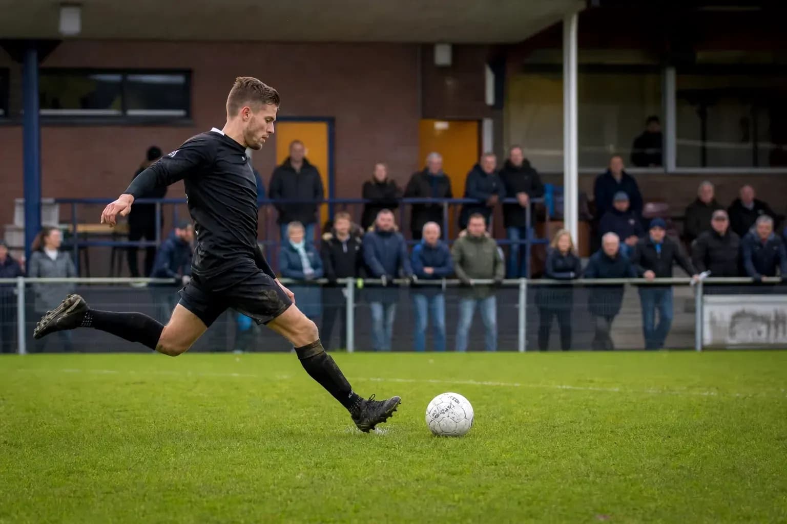 Player kicking a soccer ball during a match Player kicking a soccer ball during a match