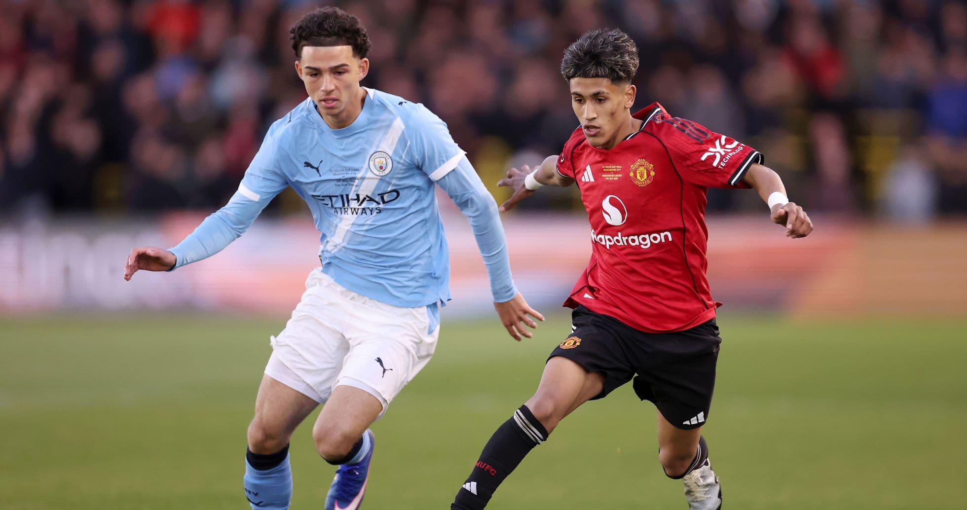 Manchester City and Manchester United players competing for the ball Manchester City and Manchester United players competing for the ball
