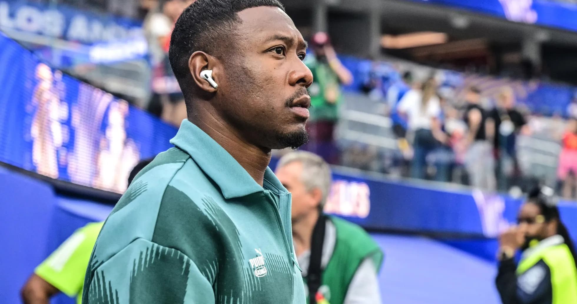 Player wearing headphones walking near stadium Player wearing headphones walking near stadium