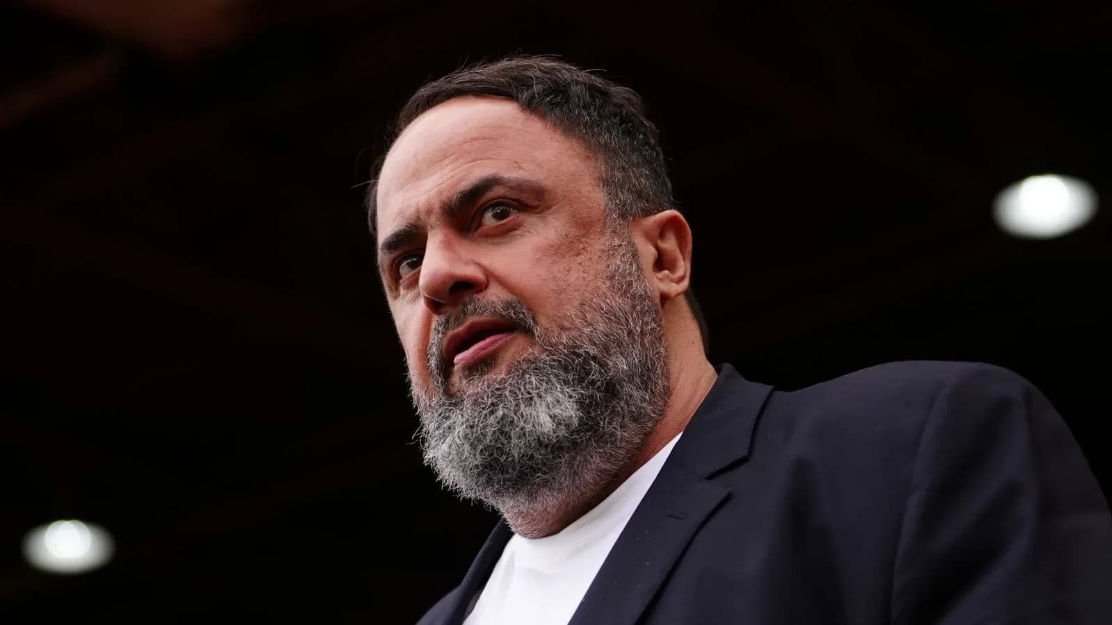 Man speaking at an event with focused expression Man speaking at an event with focused expression