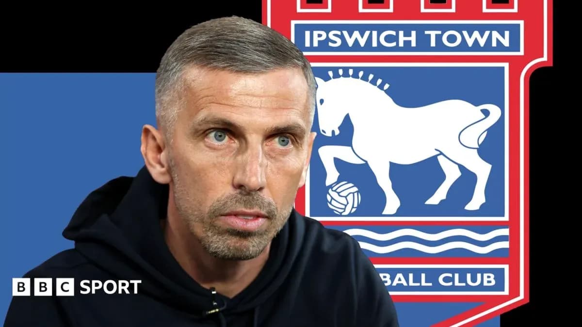 Man speaking with Ipswich Town logo in background Man speaking with Ipswich Town logo in background