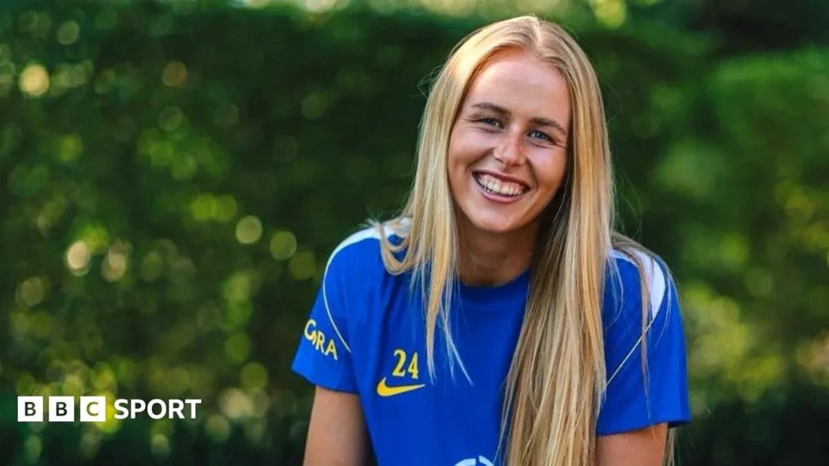 Female football player smiling in team jersey Female football player smiling in team jersey