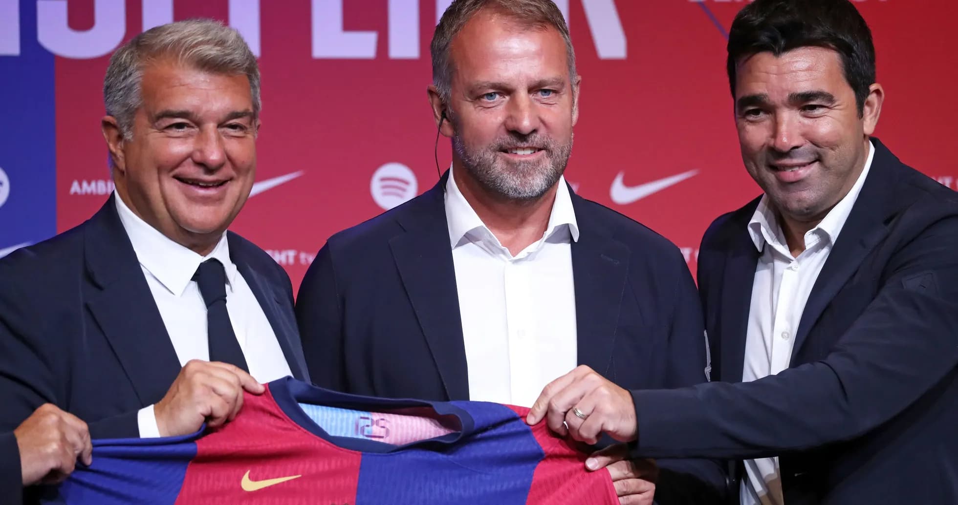 Three officials holding a Barcelona jersey at event Three officials holding a Barcelona jersey at event