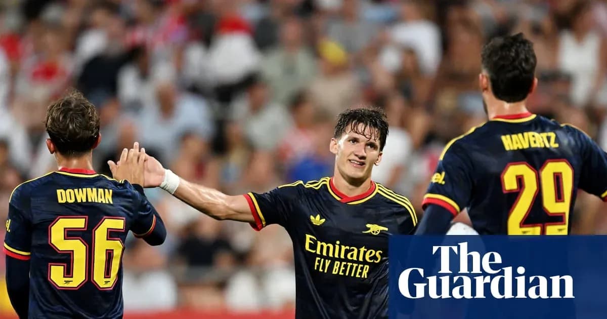 Three Arsenal players celebrating on the pitch Three Arsenal players celebrating on the pitch