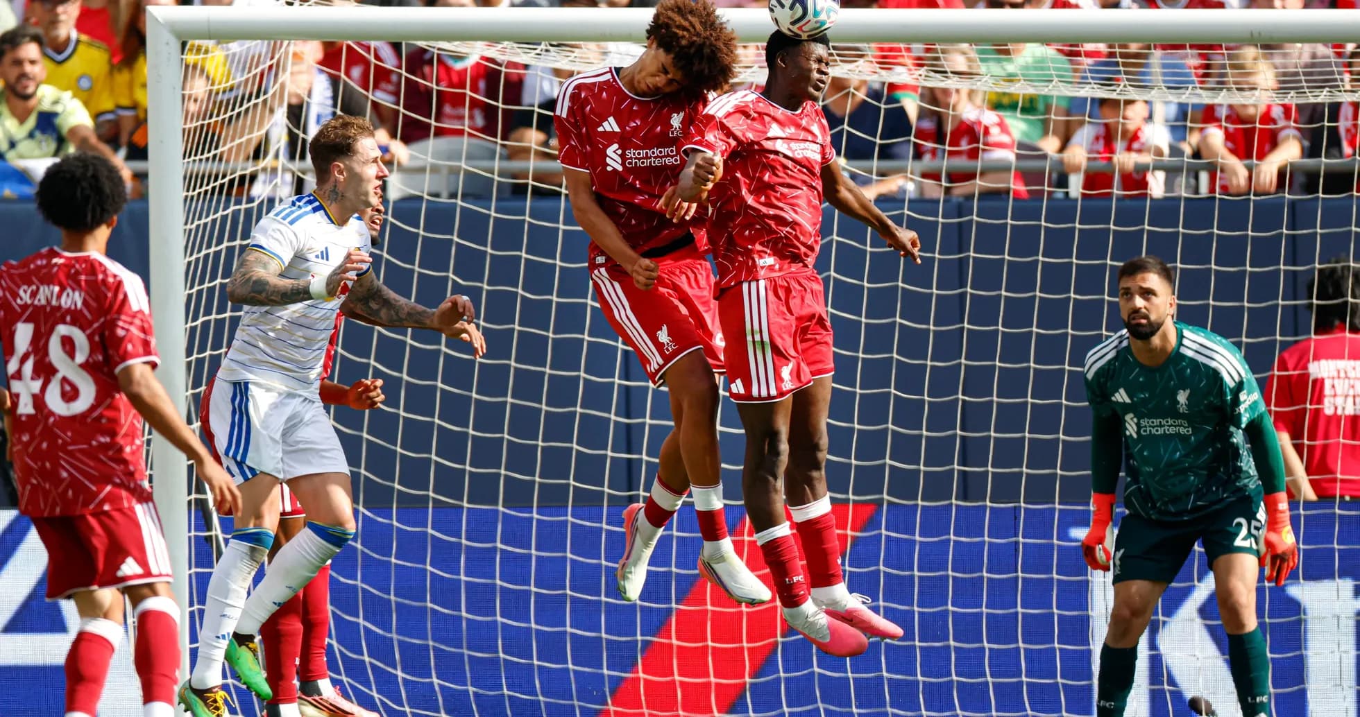 Two players heading the ball in goal area Two players heading the ball in goal area