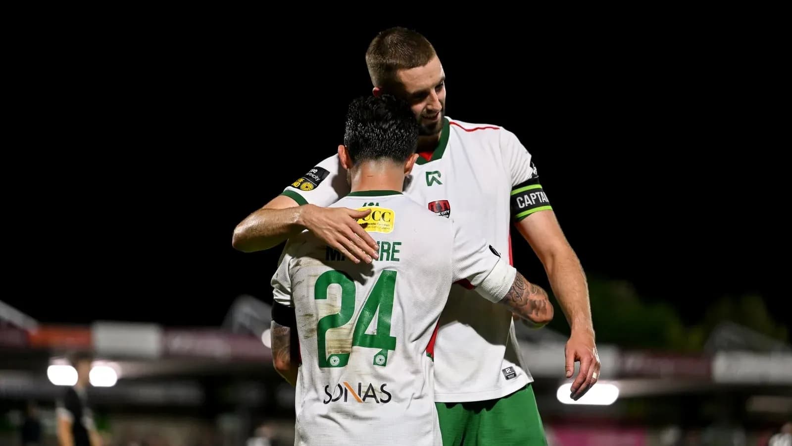 Two players embracing on the field after a match Two players embracing on the field after a match