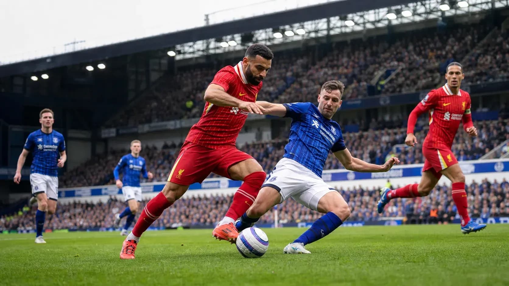 Players competing for the ball in Liverpool vs Everton match Players competing for the ball in Liverpool vs Everton match