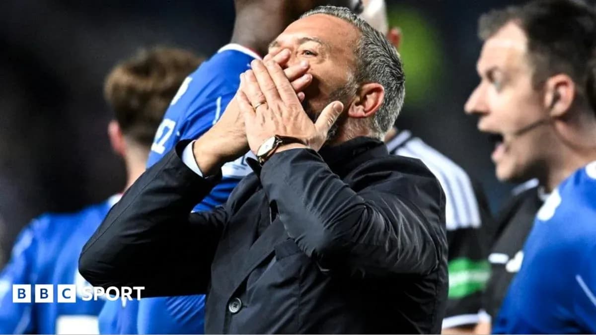Manager reacting during match with players in background Manager reacting during match with players in background