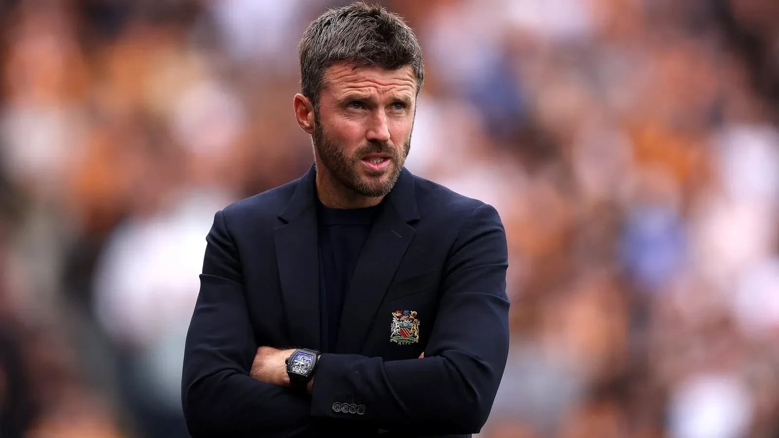 Coach observing match with arms crossed on sidelines Coach observing match with arms crossed on sidelines