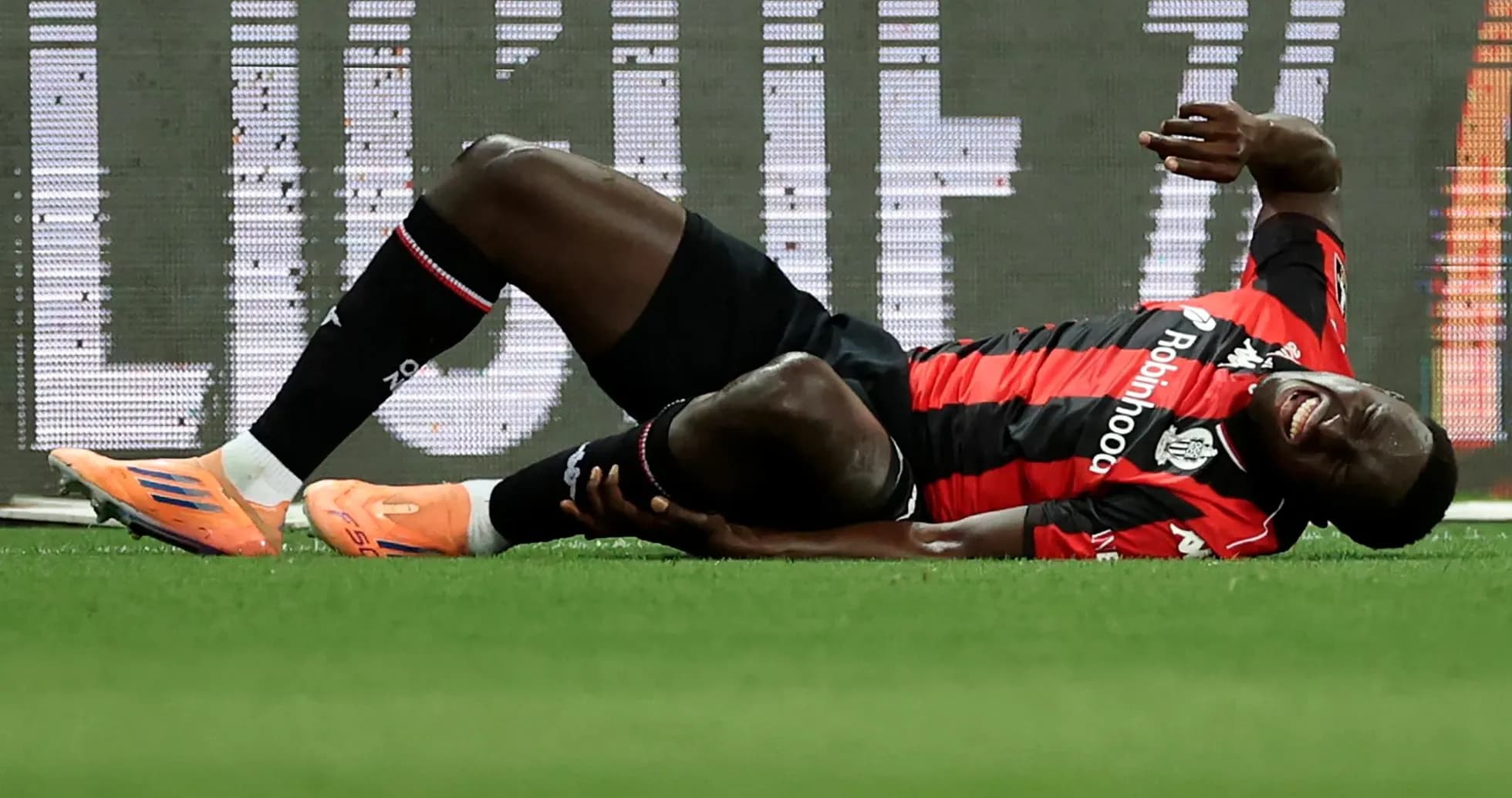 Player lying on ground holding leg in pain Player lying on ground holding leg in pain