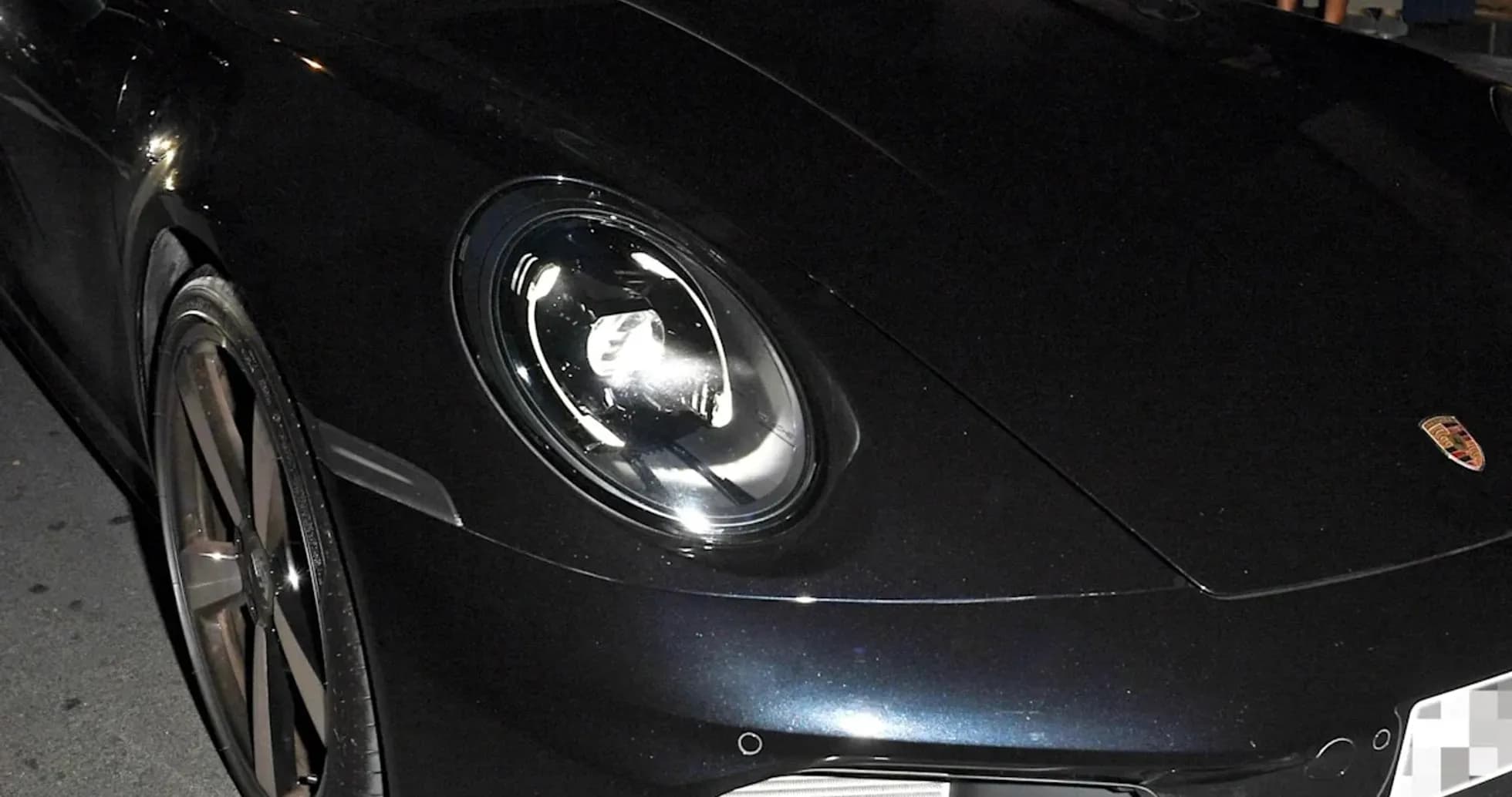 Two men inside a black Porsche car at night Two men inside a black Porsche car at night