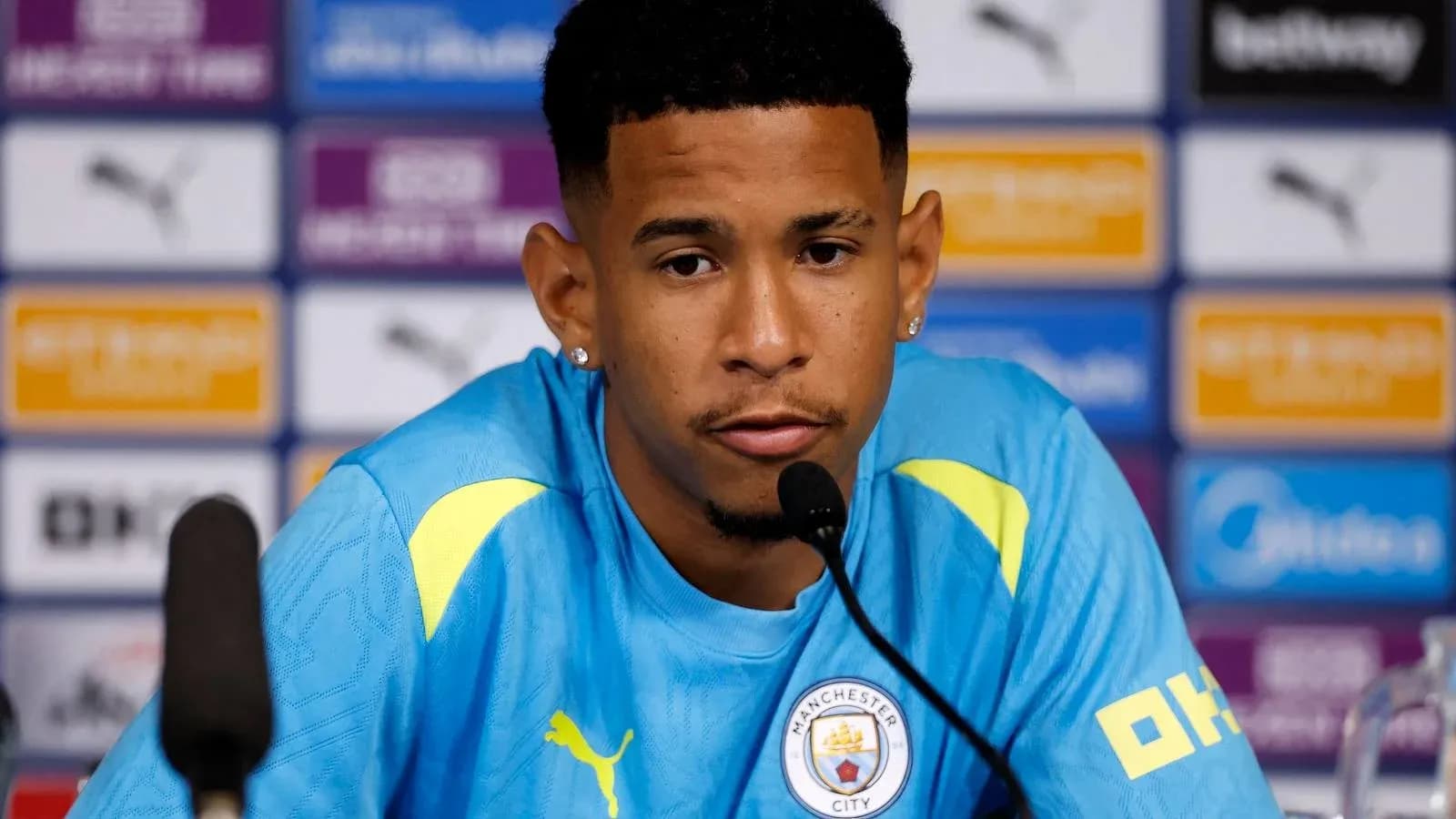 Player at press conference speaking into microphone Player at press conference speaking into microphone