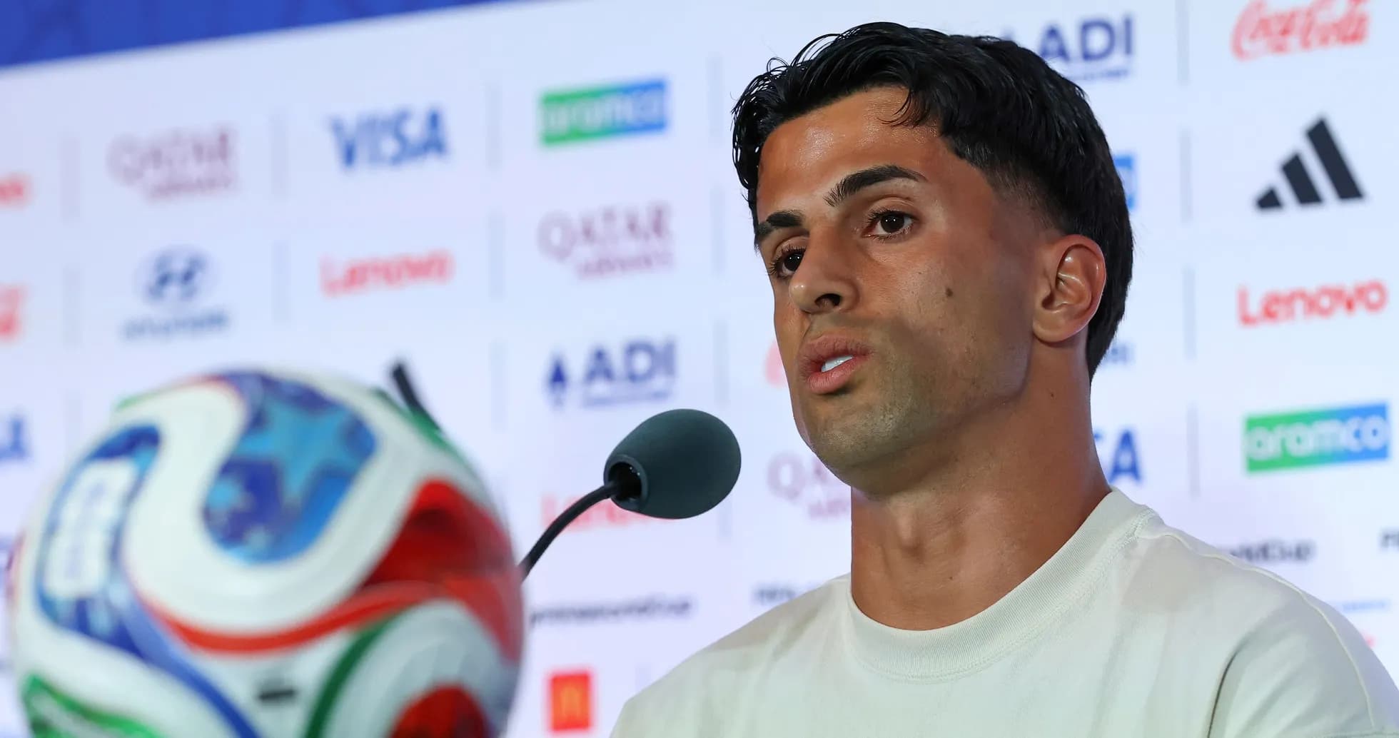 Player speaking at press conference with soccer ball Player speaking at press conference with soccer ball