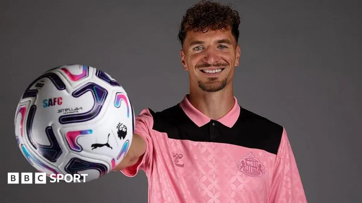 Player holding a soccer ball and smiling Player holding a soccer ball and smiling