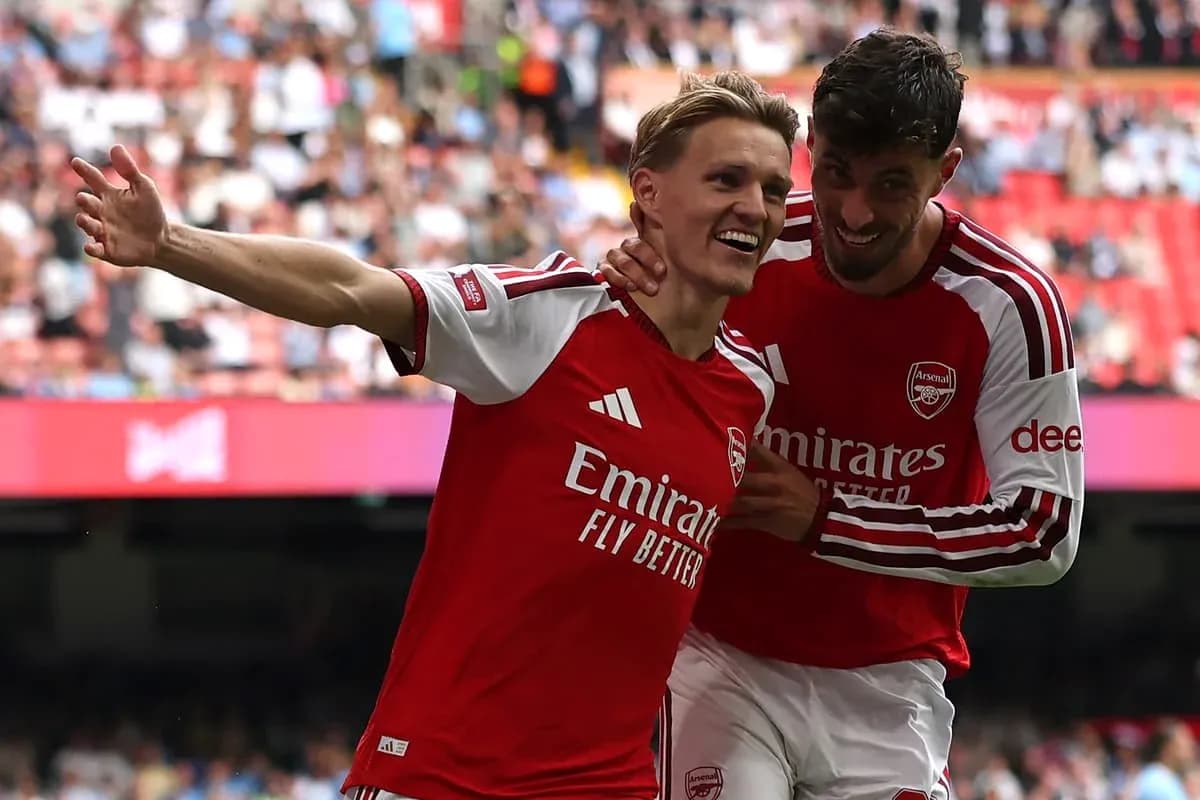 Two Arsenal players celebrating a goal together Two Arsenal players celebrating a goal together