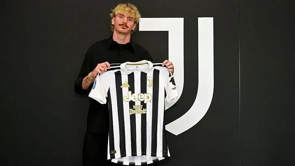 Player holding Juventus jersey at signing event Player holding Juventus jersey at signing event