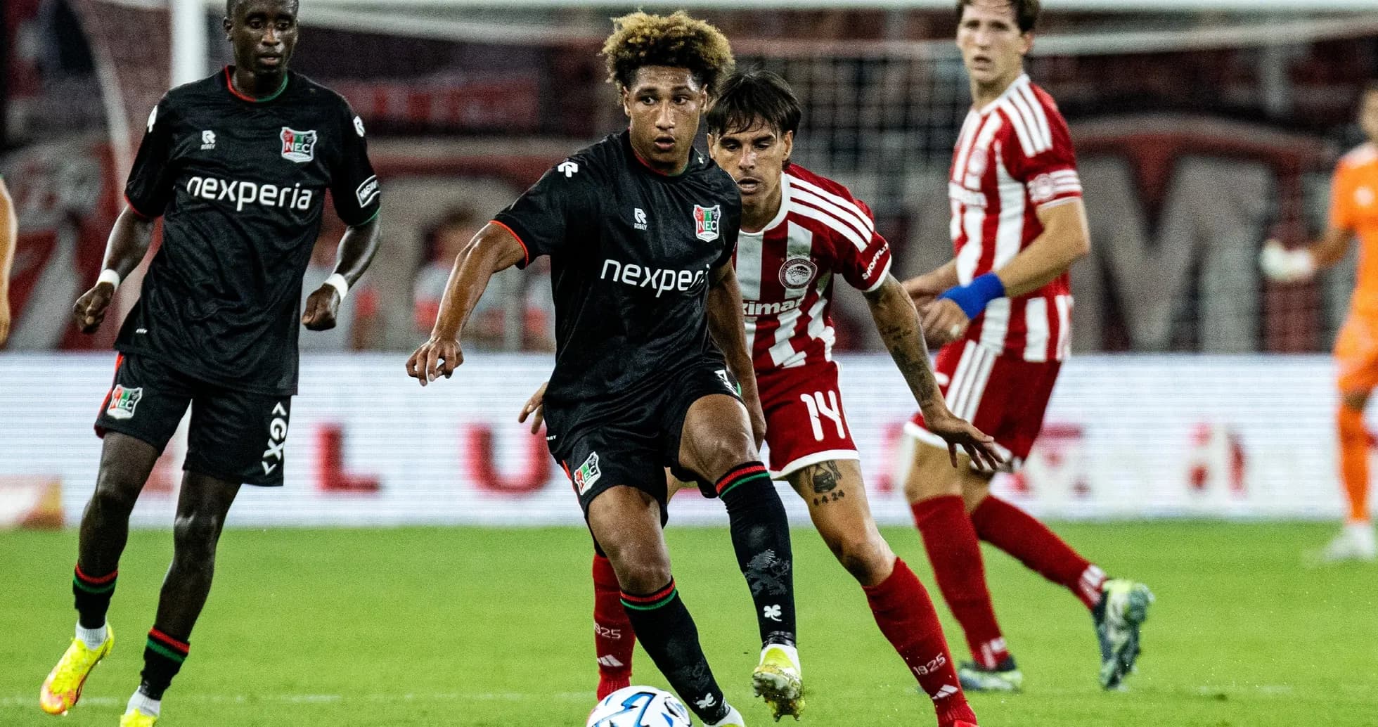 NEC Nijmegen player dribbling past Olympiakos defender NEC Nijmegen player dribbling past Olympiakos defender