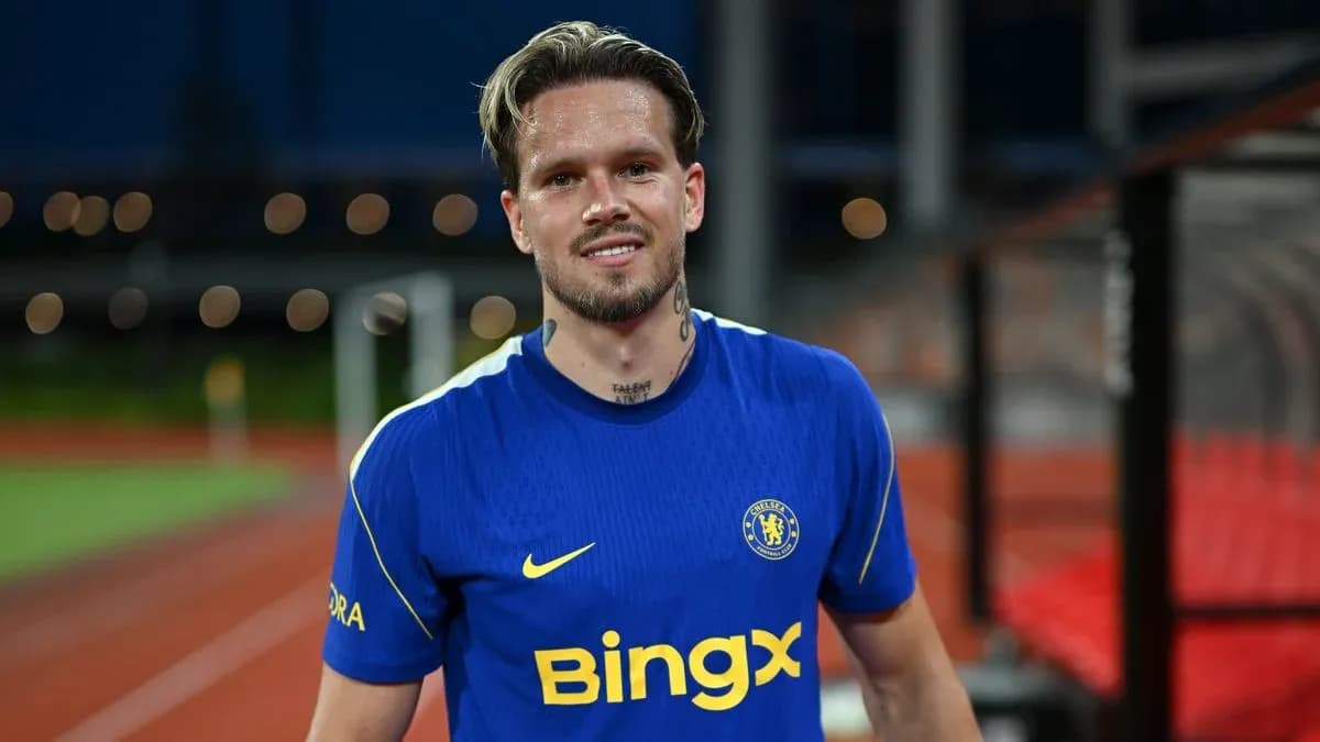 Player in blue Chelsea kit smiling on pitch Player in blue Chelsea kit smiling on pitch