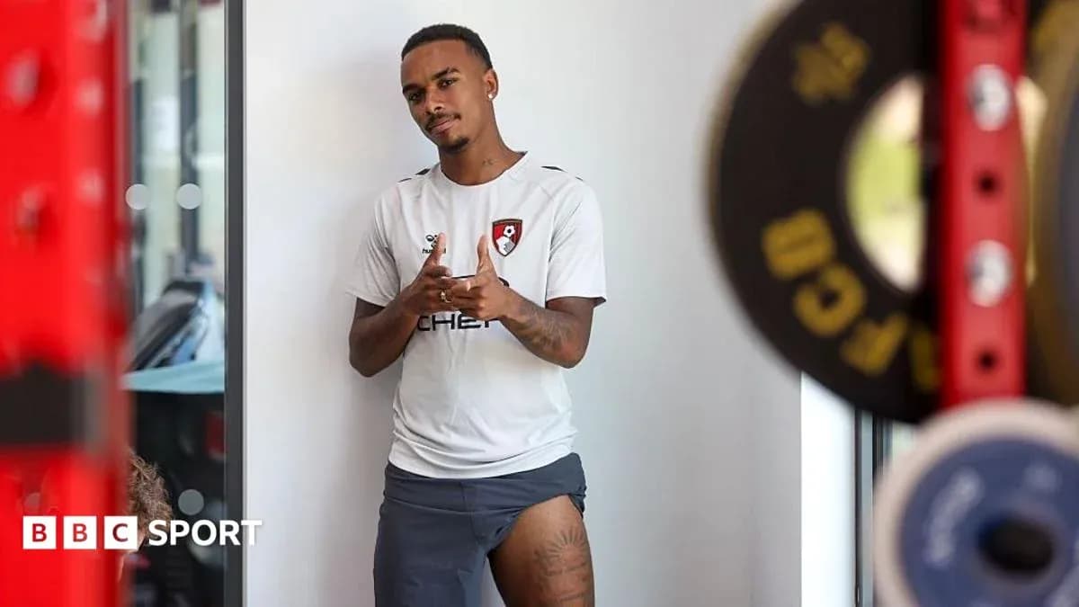 Player posing in training gear next to weights Player posing in training gear next to weights
