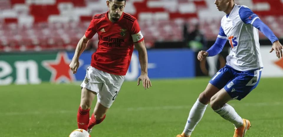 Benfica player dribbling past Lech Poznan opponent Benfica player dribbling past Lech Poznan opponent