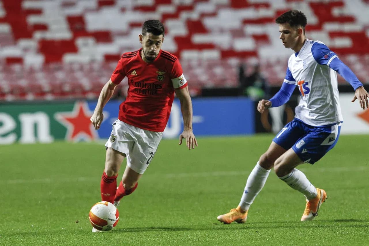 Benfica player dribbling past Lech Poznan opponent Benfica player dribbling past Lech Poznan opponent
