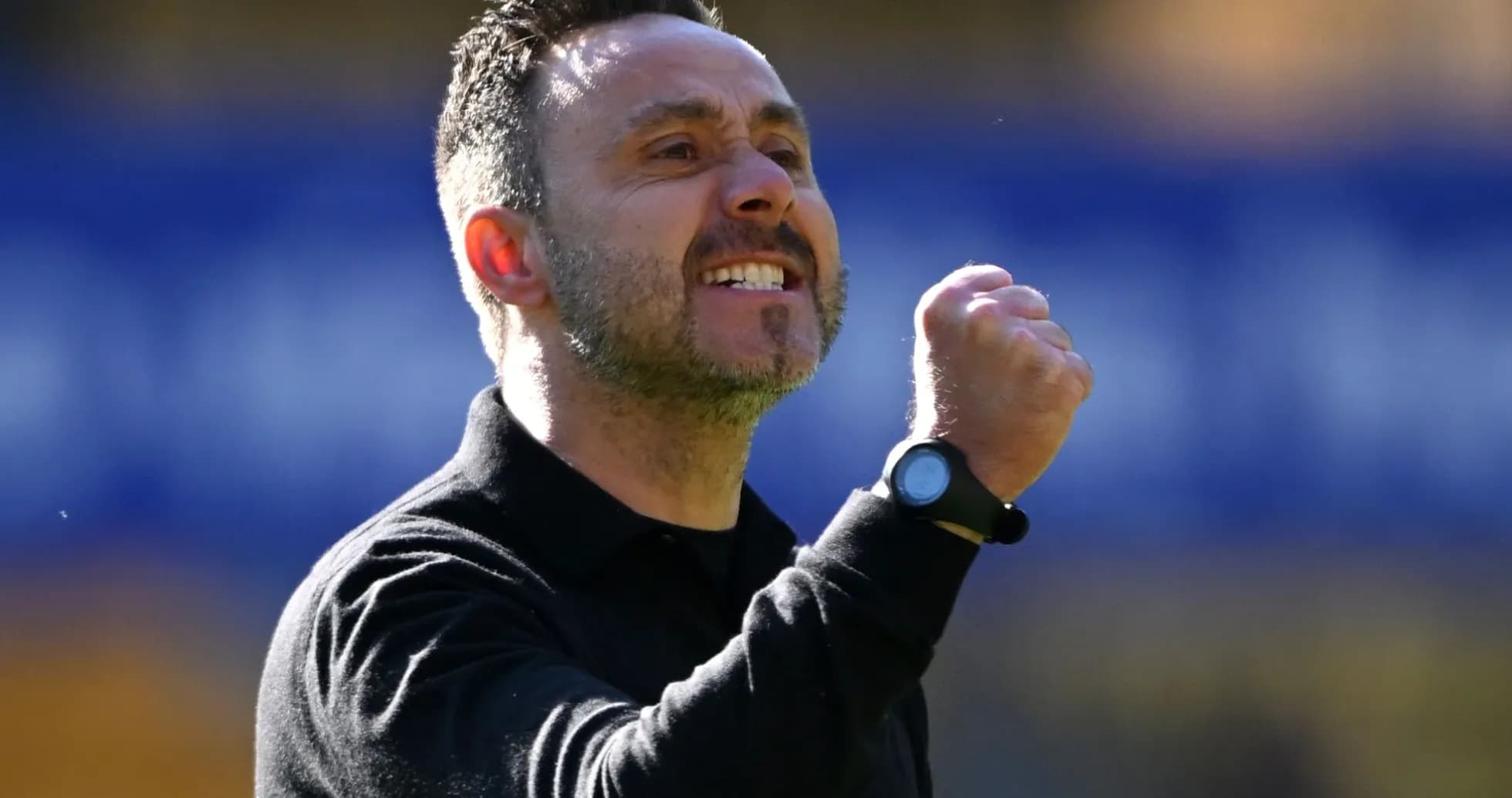 Coach celebrating with a clenched fist on sidelines Coach celebrating with a clenched fist on sidelines