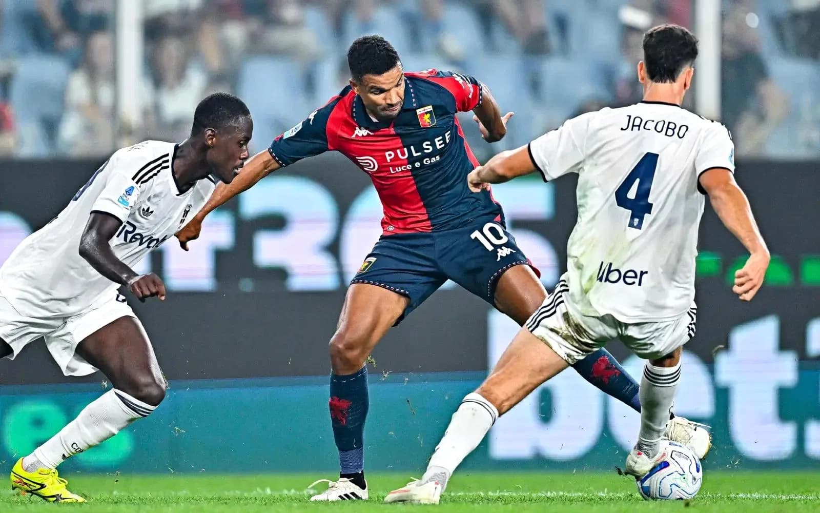 Genoa player dribbling past Como defenders Genoa player dribbling past Como defenders