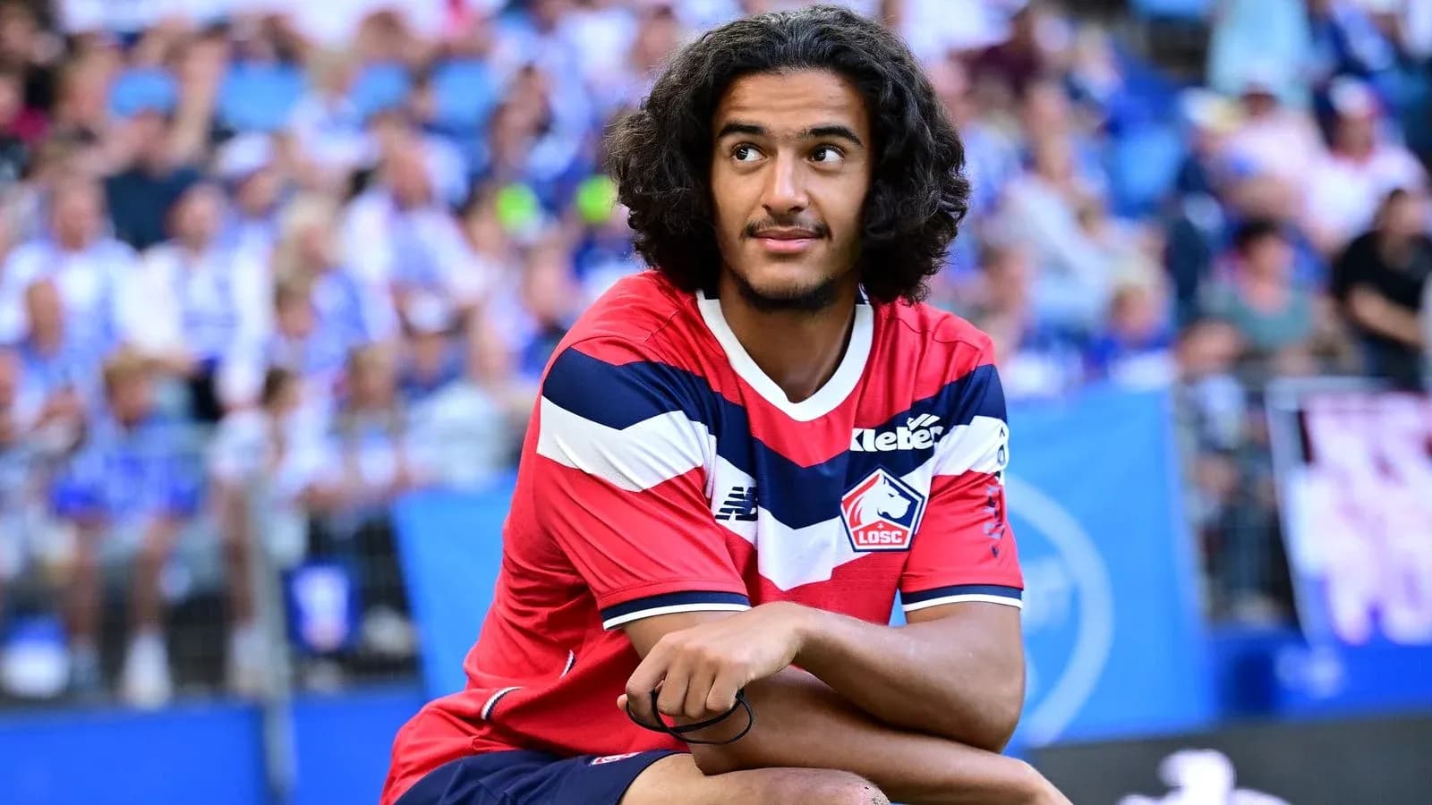 Player in Lille OSC jersey sitting on the pitch Player in Lille OSC jersey sitting on the pitch