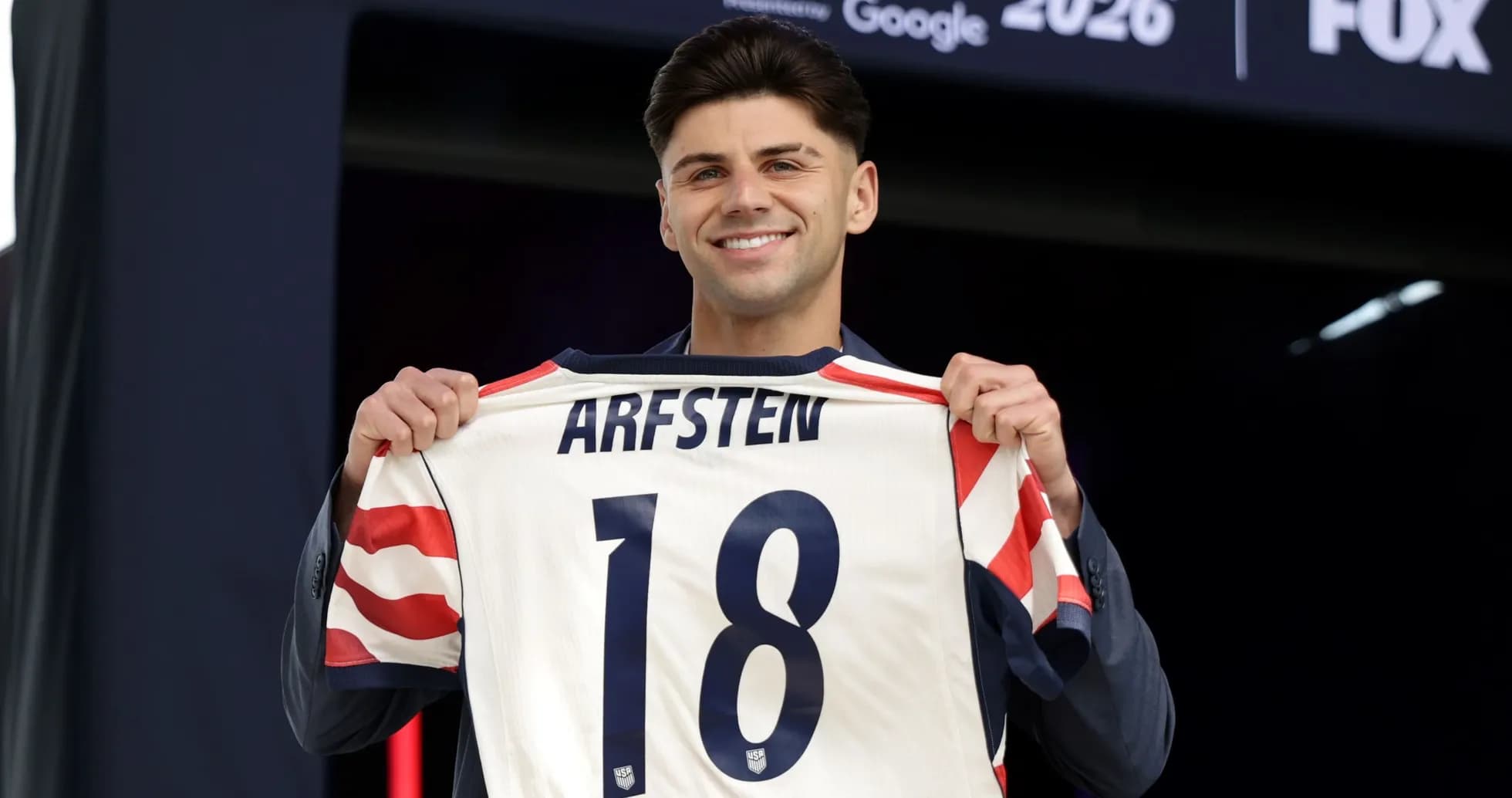 Player holding jersey with 'ARFSTEN 18' at event Player holding jersey with 'ARFSTEN 18' at event