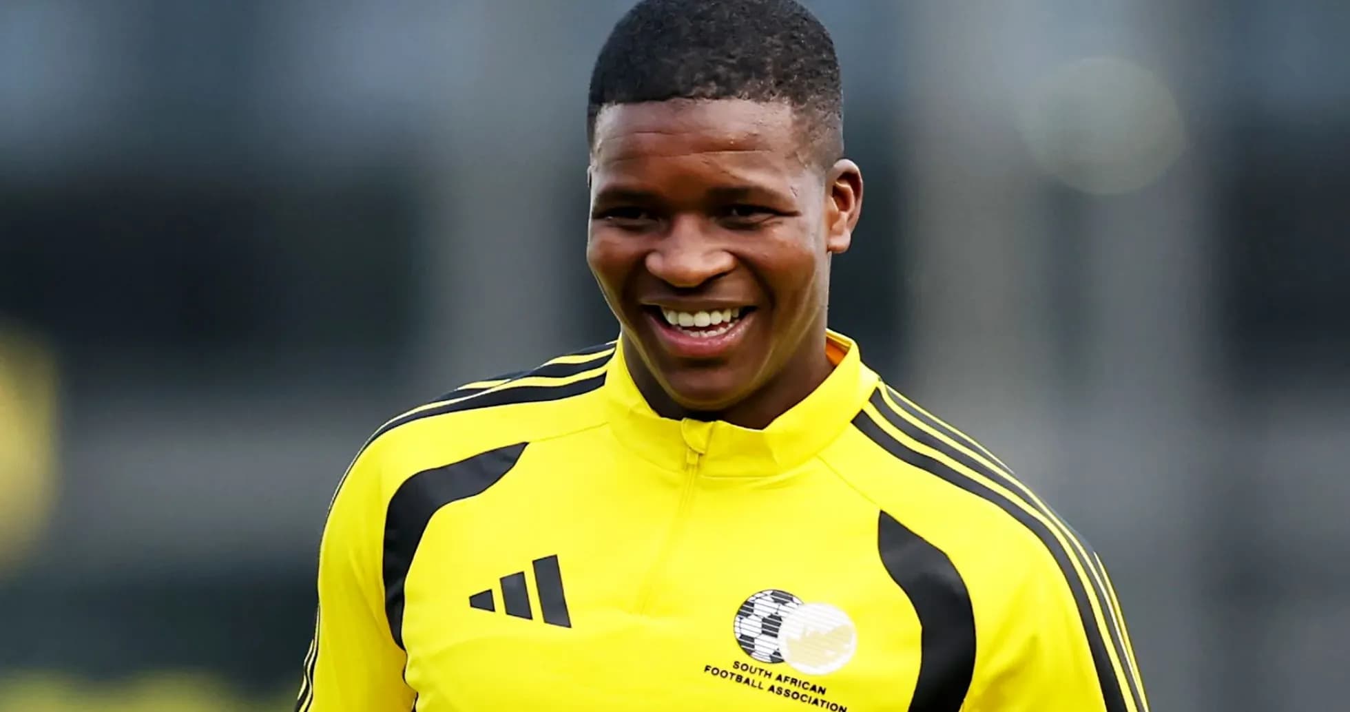 Player smiling during training session in yellow kit Player smiling during training session in yellow kit