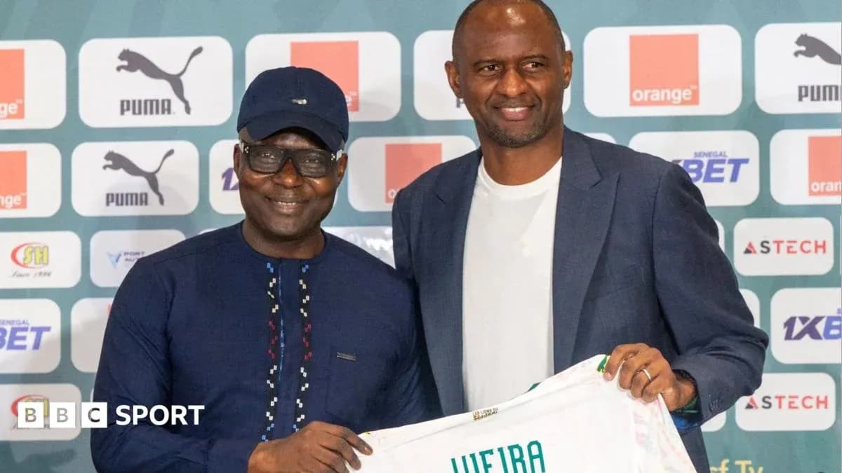Two men holding a football shirt at press event Two men holding a football shirt at press event
