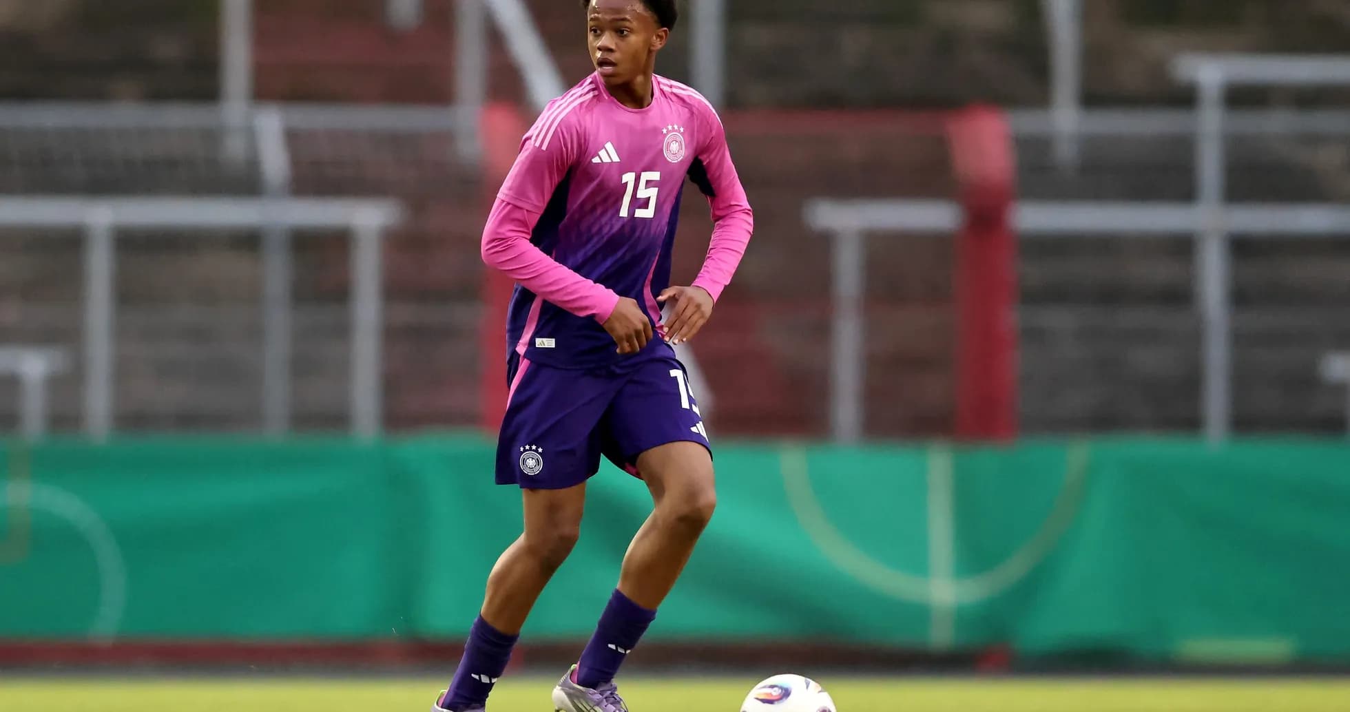 Player in pink and purple uniform during training session Player in pink and purple uniform during training session