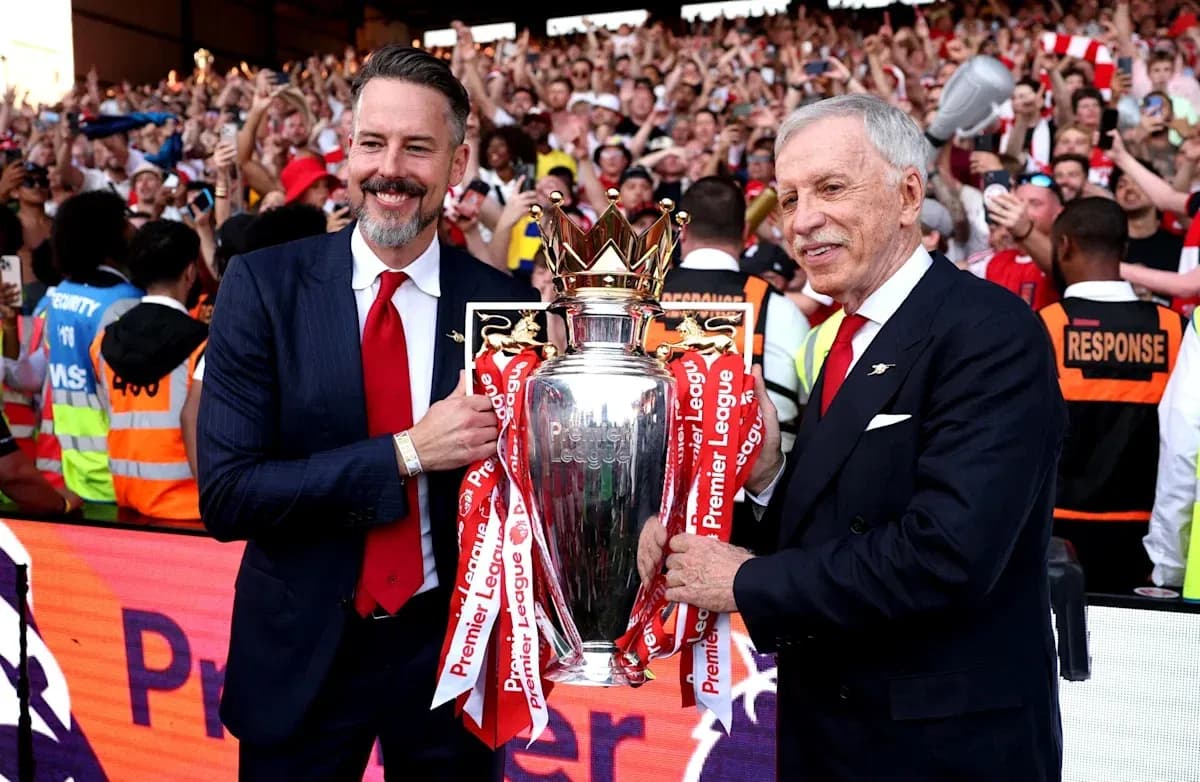 Two men holding the Premier League trophy with fans Two men holding the Premier League trophy with fans