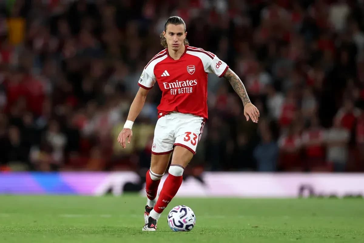 Arsenal player running with the ball on field Arsenal player running with the ball on field