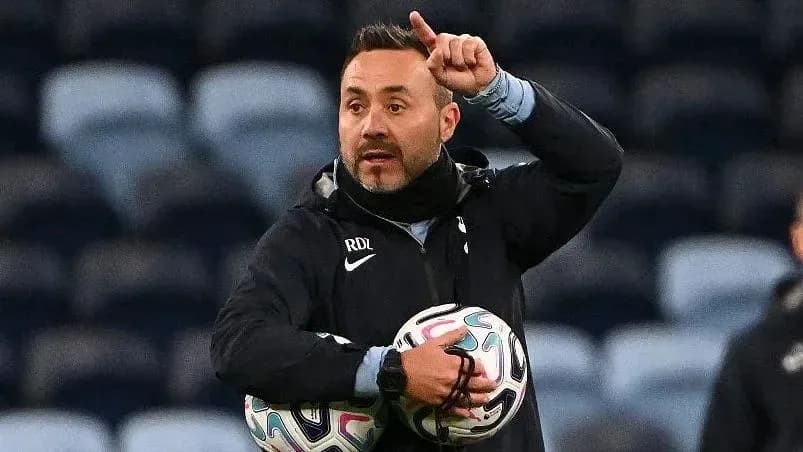 Coach instructing players while holding footballs Coach instructing players while holding footballs