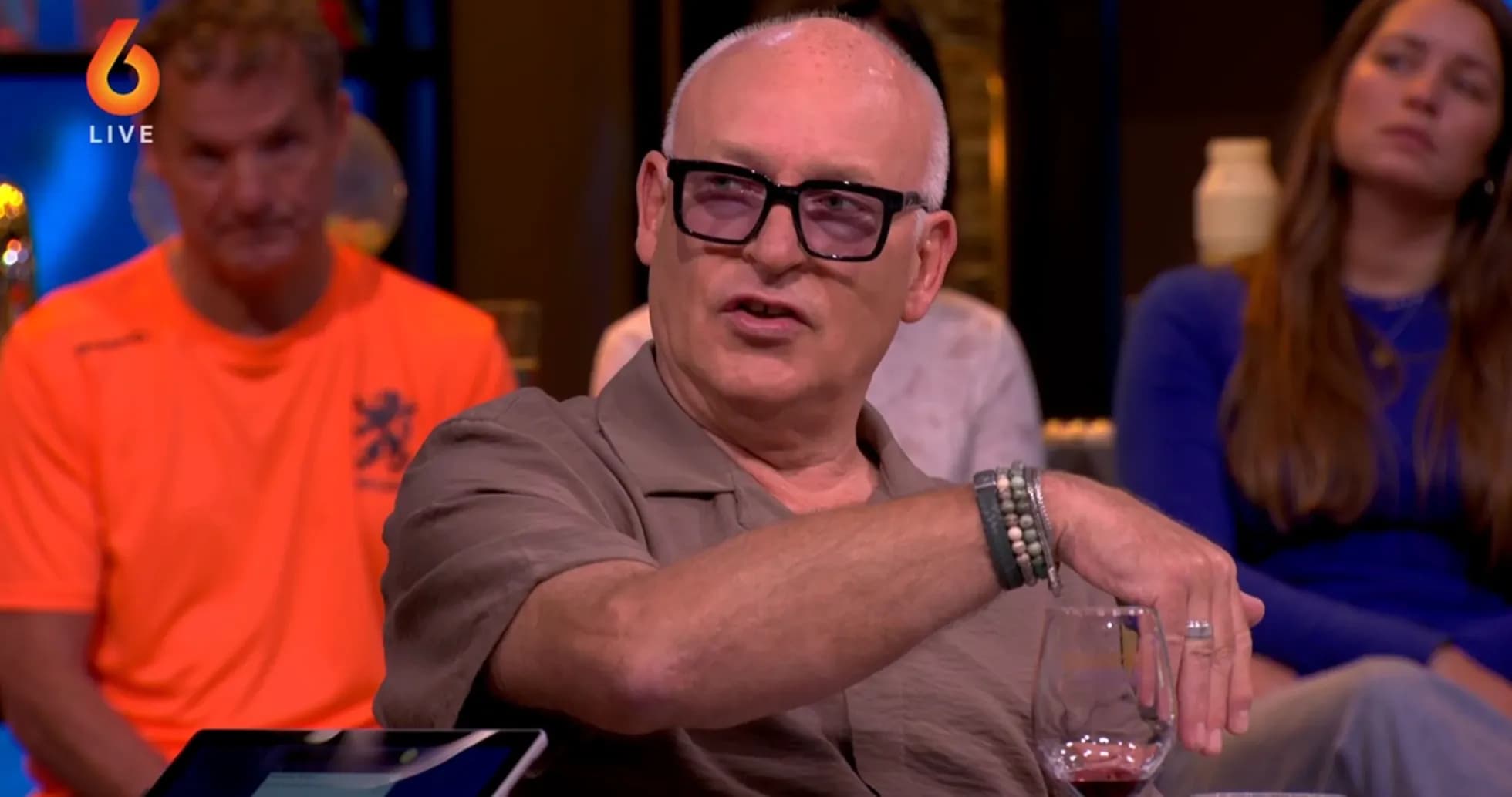 Man speaking during talk show with audience behind Man speaking during talk show with audience behind
