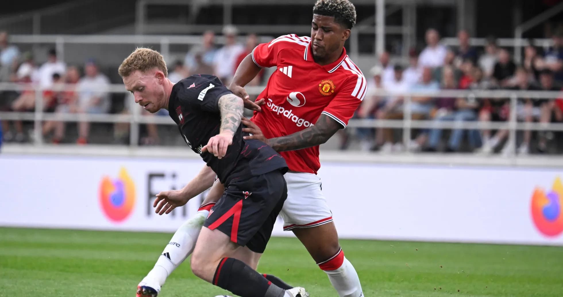 Player tackling opponent during a football match Player tackling opponent during a football match