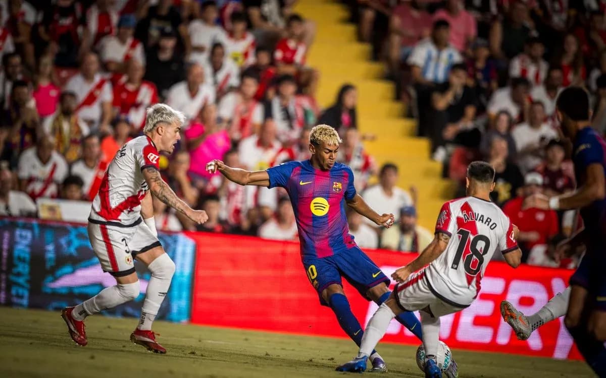 Barcelona player dribbling against Rayo Vallecano defenders Barcelona player dribbling against Rayo Vallecano defenders