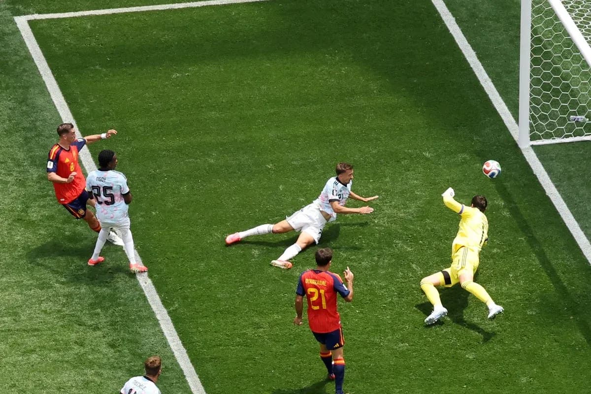 Player attempting to score as goalkeeper stretches Player attempting to score as goalkeeper stretches
