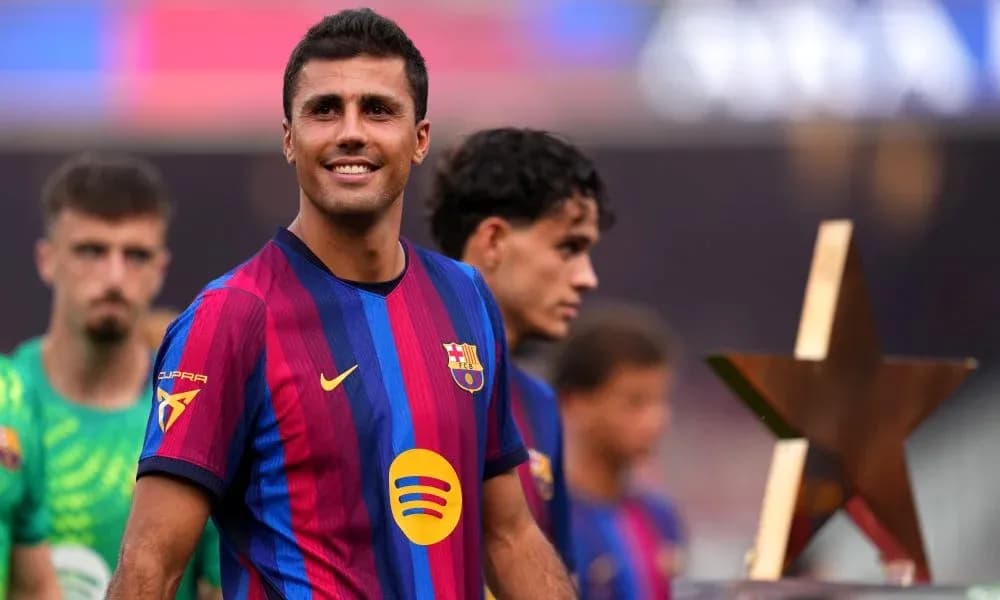 Player smiling while holding a trophy on field Player smiling while holding a trophy on field