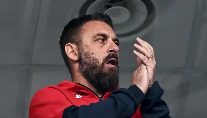 Man in red jacket clapping in a stadium Man in red jacket clapping in a stadium